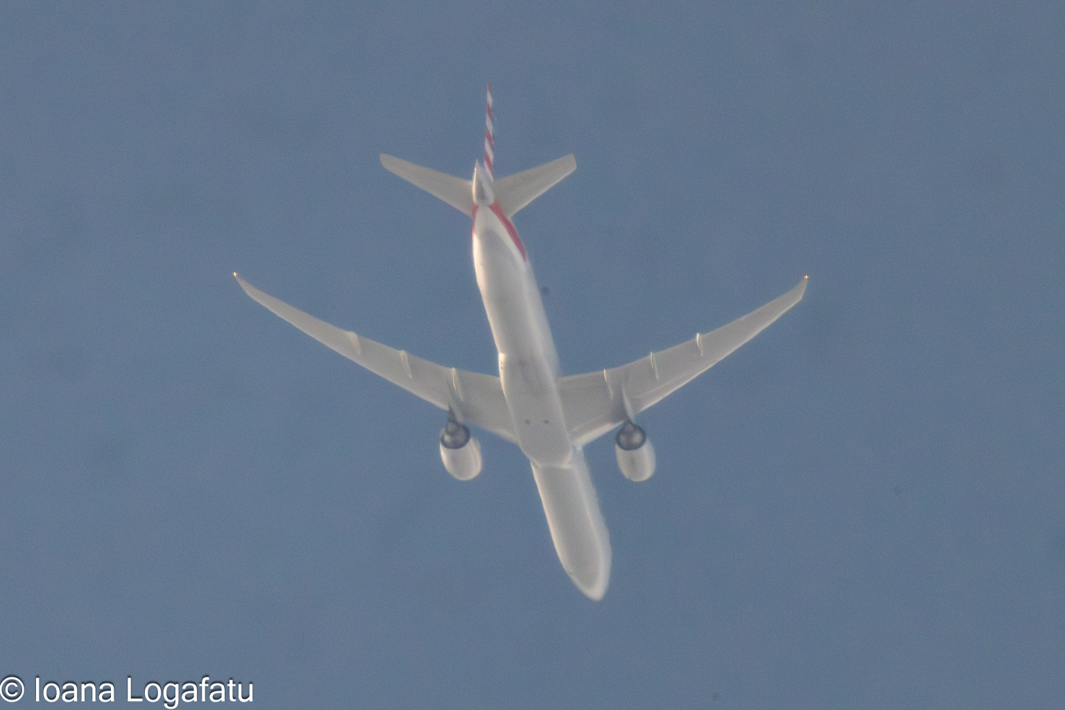 Blue skies and soaring planes above city